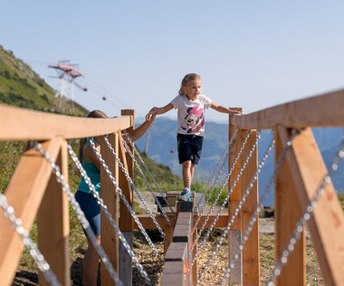 Dieses Bild zeigt ein Mädchen, dass im Motorikpark auf der Schlossalm balanciert