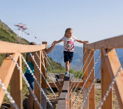 Dieses Bild zeigt ein Mädchen, dass im Motorikpark auf der Schlossalm balanciert