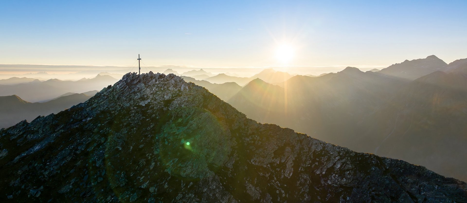 Dieses Bild zeigt den Graukogel mit Gipfelkreuz bei abendlicher Stimmung