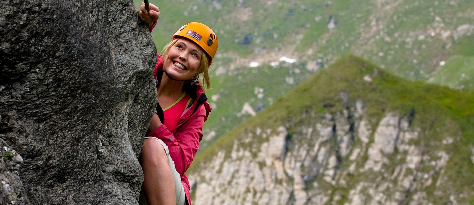 Auf diesem Bild ist zu sehen, wie eine Frau auf einem Klettersteig zum Hochalmblick in Gastein klettert