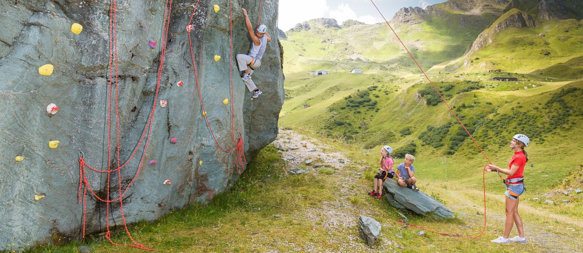 Dieses Bild zeigt eine Gruppe, die auf der Schlossalm auf einem Felsen klettert