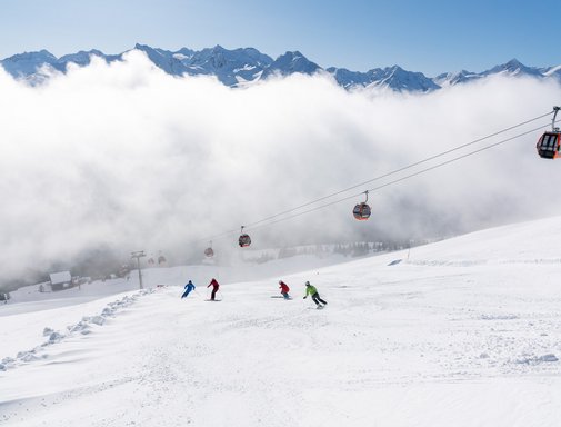 Dieses Bild zeigt eine Gruppe von Skifahrern, die auf einer Piste in Gastein fährt