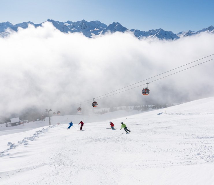 Dieses Bild zeigt eine Gruppe von Skifahrern, die auf einer Piste in Gastein fährt