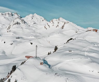 Der Schlossalmblick mit der Piste H4 vor traumhaftem Winter-Bergpanorama
