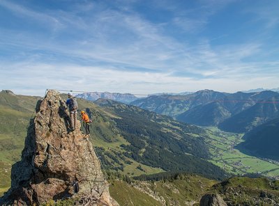 Dieses Bild zeigt zwei Menschen, die den Klettersteig Hirschinger in luftiger Höhe bestreiten 