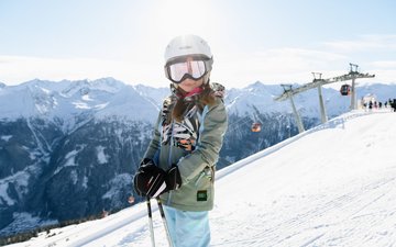 Dieses Bild zeigt ein Mädchen, die auf einer Piste in Gastein steht und in die Kamera lächelt