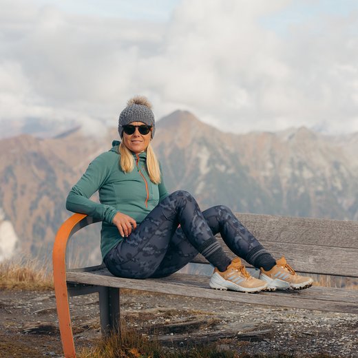 Dieses Bild zeigt eine Frau, die auf einer Bank in Gastein im Herbst sitzt