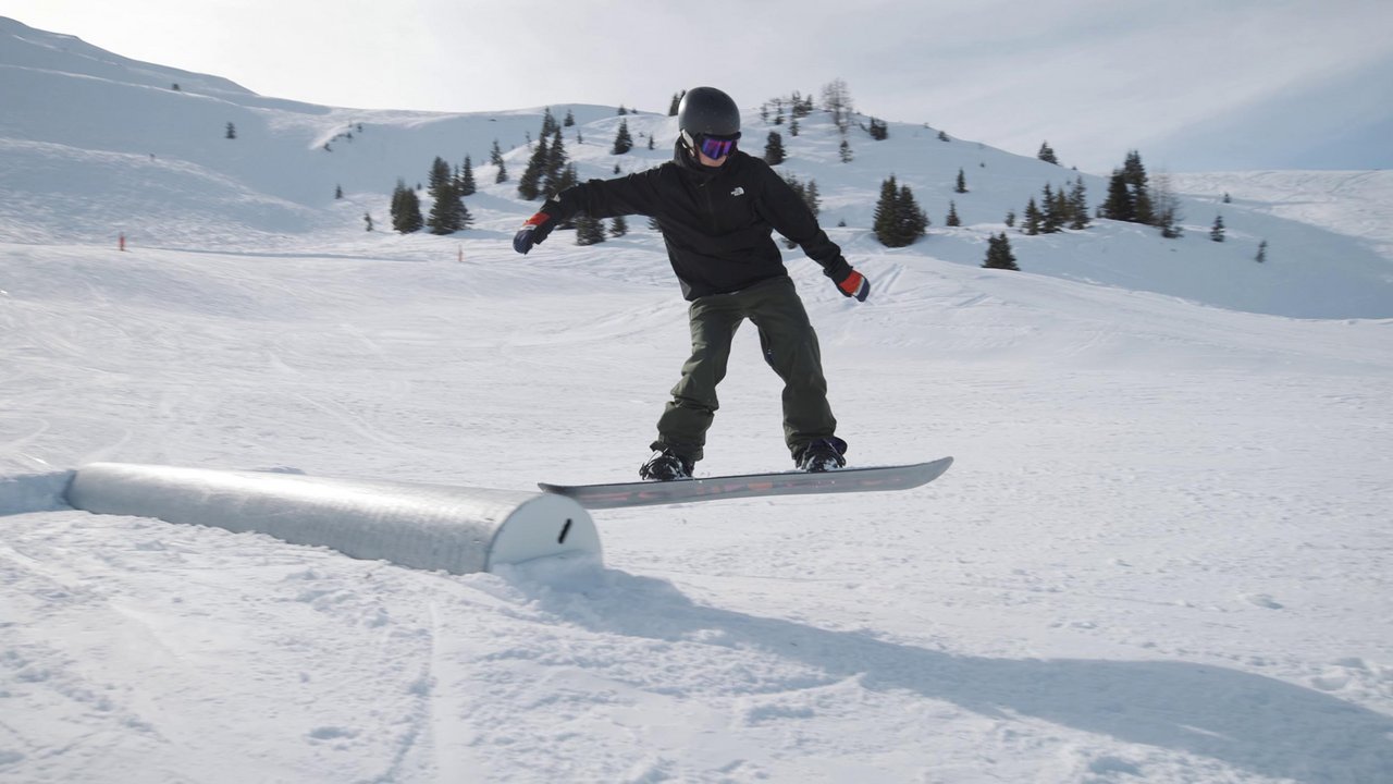Auf diesem Bild ist ein Snowboarder, der über ein Hindernis im Snowpark am Stubnerkogel gleitet zu sehen