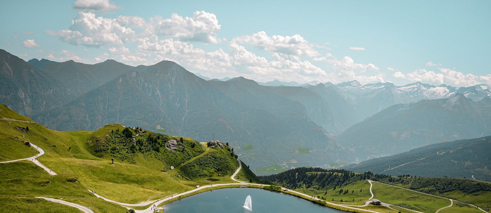 Dieses Bild zeigt eine Luftaufnahme von dem Schlossalmsee mit zwei Wasserfontänen