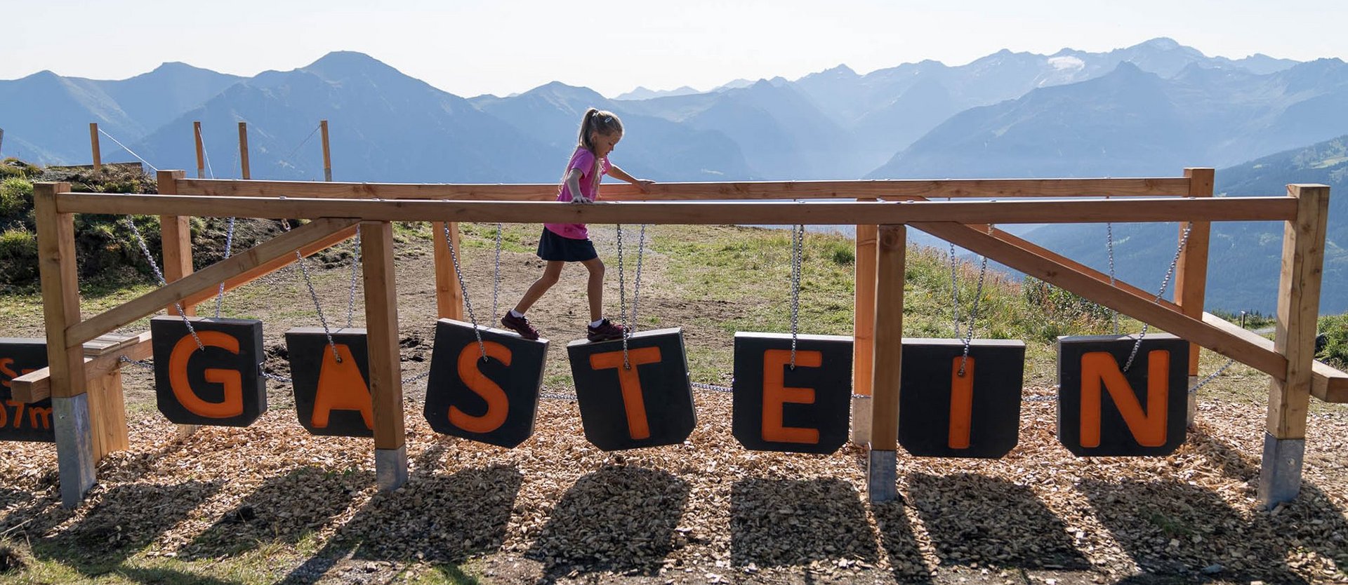 Dieses Bild zeigt ein Mädchen, dass im Motorikweg auf der Schlossalm balanciert