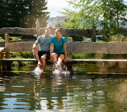 Dieses Bild zeigt ein Paar, dass sich an einem kleinen See am Graukogel erfrischt