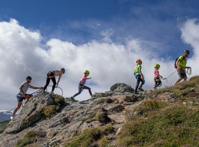 Dieses Bild zeigt eine Familie mit Kindern, die einen Klettersteig auf der Schlossalm absolviert.