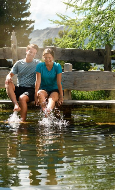 Dieses Bild zeigt ein Paar, dass sich an einem kleinen See am Graukogel erfrischt