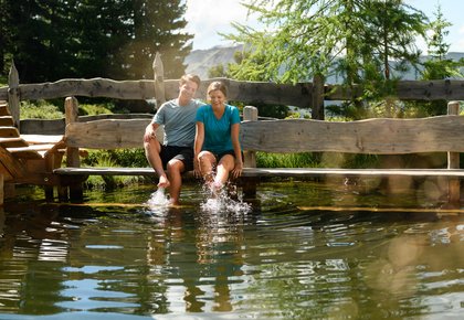 Dieses Bild zeigt ein Paar, dass sich an einem kleinen See am Graukogel erfrischt