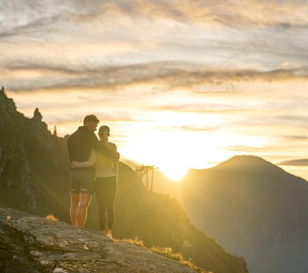 Dieses Bild zeigt ein Pärchen, dass einen malerischen Sonnenaufgang auf der Schlossalm genießt