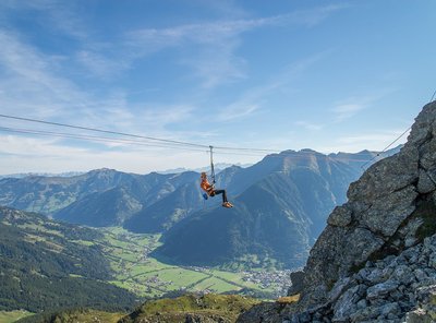 Dieses Bild zeigt eine Frau, die einen Flying Fox beim Hirschinger Klettersteig benutzt