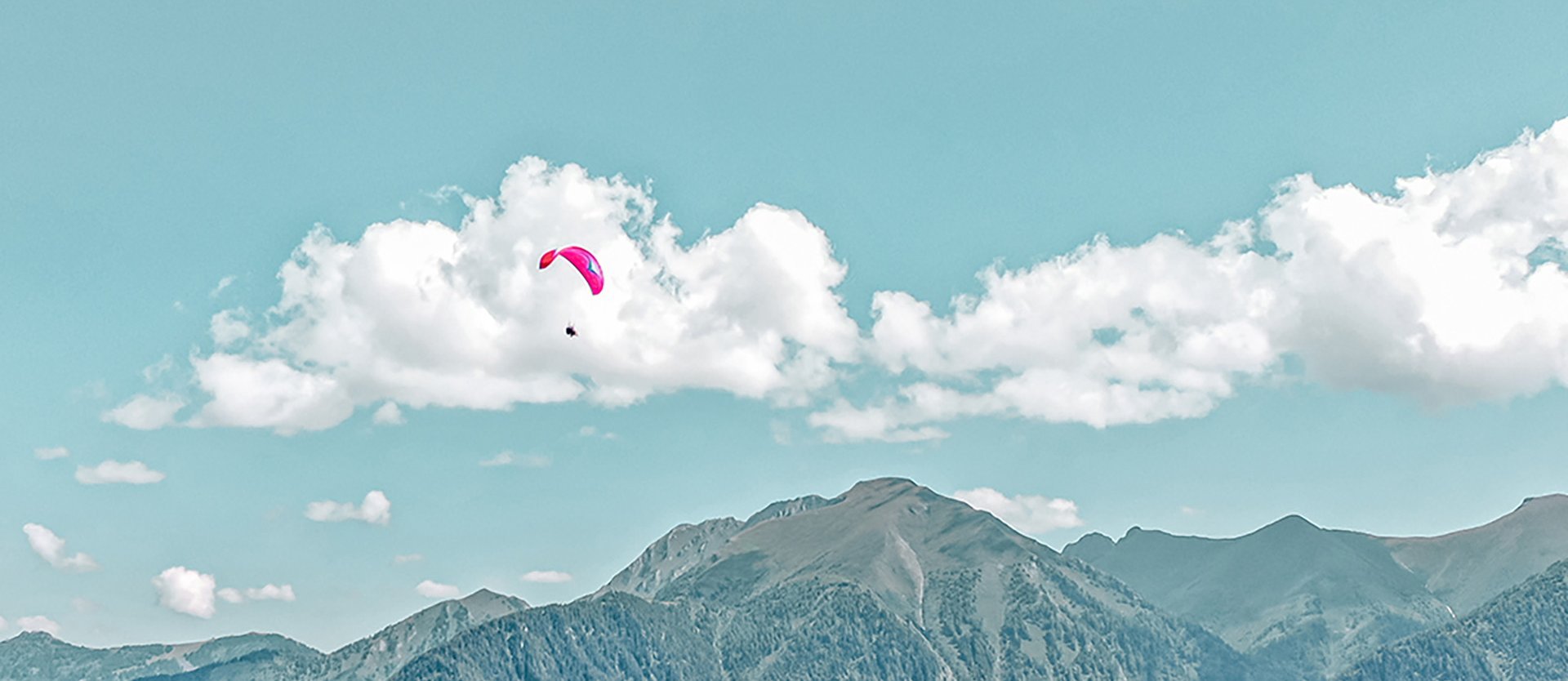 Dieses Bild zeigt einen Paragleiter, der über Gastein fliegt
