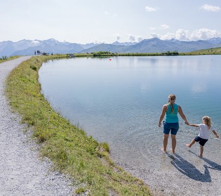 Dieses Bild zeigt Mutter und Tochter, die sich im Schlossalmsee die Füße abkühlen