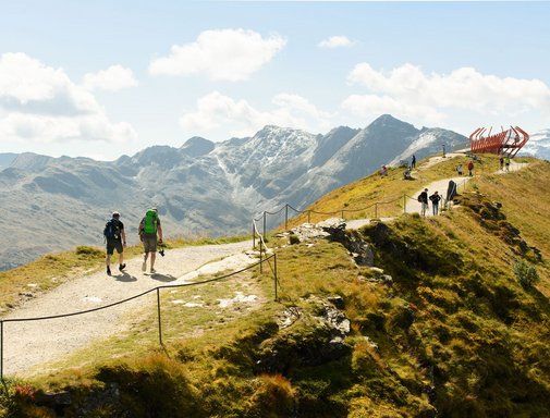 Dieses Bild zeigt Wanderer, die zu der Aussichtsplattform Glocknerblick am Stubnerkogel wandern