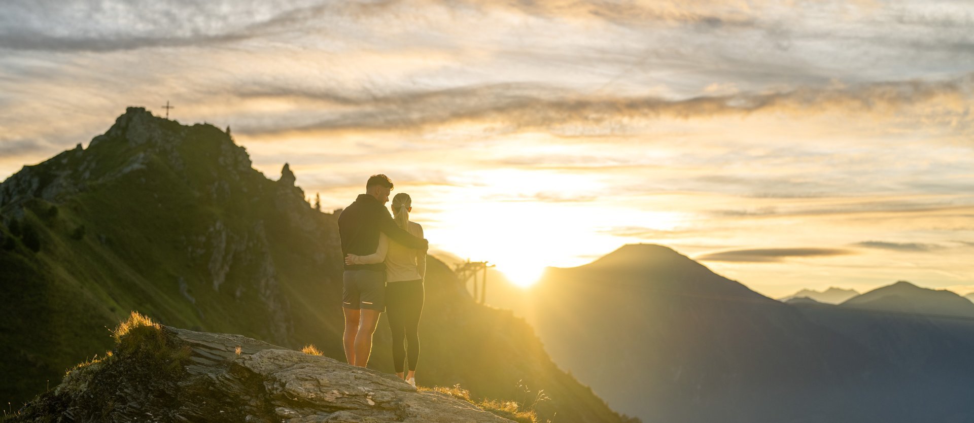 Dieses Bild zeigt ein Pärchen, dass einen malerischen Sonnenaufgang auf der Schlossalm genießt