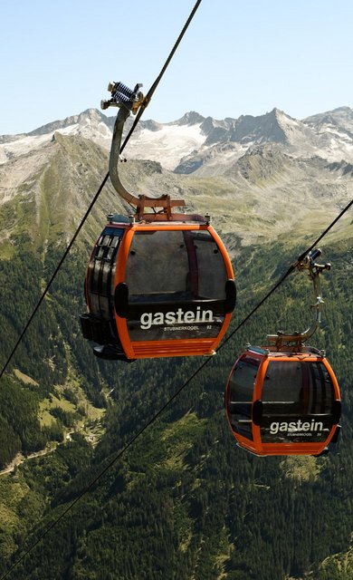 Dieses Bild zeigt zwei Gondeln der Stubnerkogelbahn mit einem sommerlichen Bergpanorama im Hintergrund