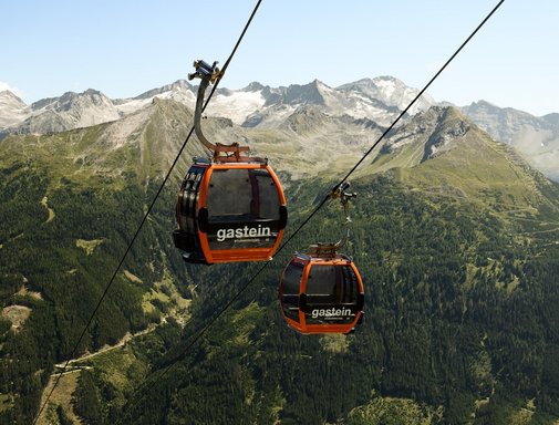 Dieses Bild zeigt zwei Gondeln der Stubnerkogelbahn mit einem sommerlichen Bergpanorama im Hintergrund