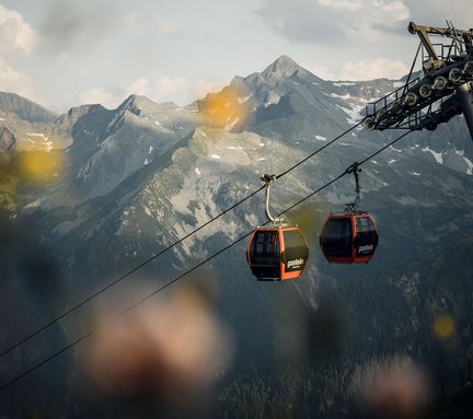 Dieses Bild zeigt zwei Gondeln und eine Stütze der Stubnerkogelbahn am Abend
