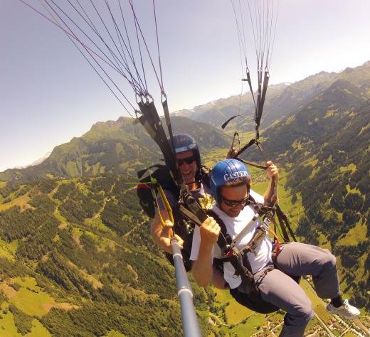 Dieses Bild zeigt zwei Menschen die über Gastein Tandem-Paragleiten