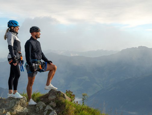Dieses Bild zeigt ein Pärchen, dass einen Klettersteig auf der Schlossalm absolviert hat und nun die Aussicht genießt